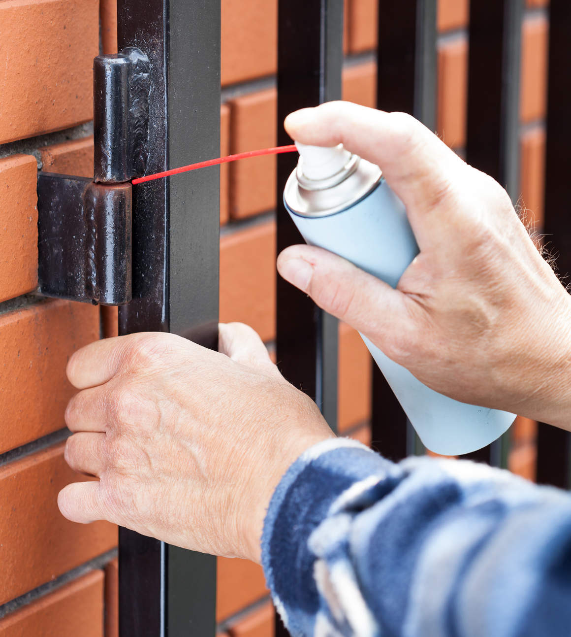 Man,Repairing,A,Lock,On,The,Gate