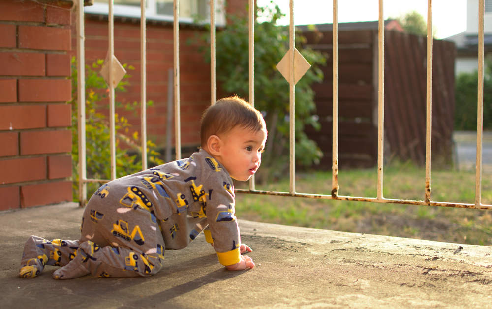 Baby crawlin on front porch near gate