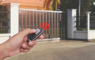 Lady opening her automatic gate with control (Top 5 Reasons Your Home Would Benefit From an Automatic Gate)
